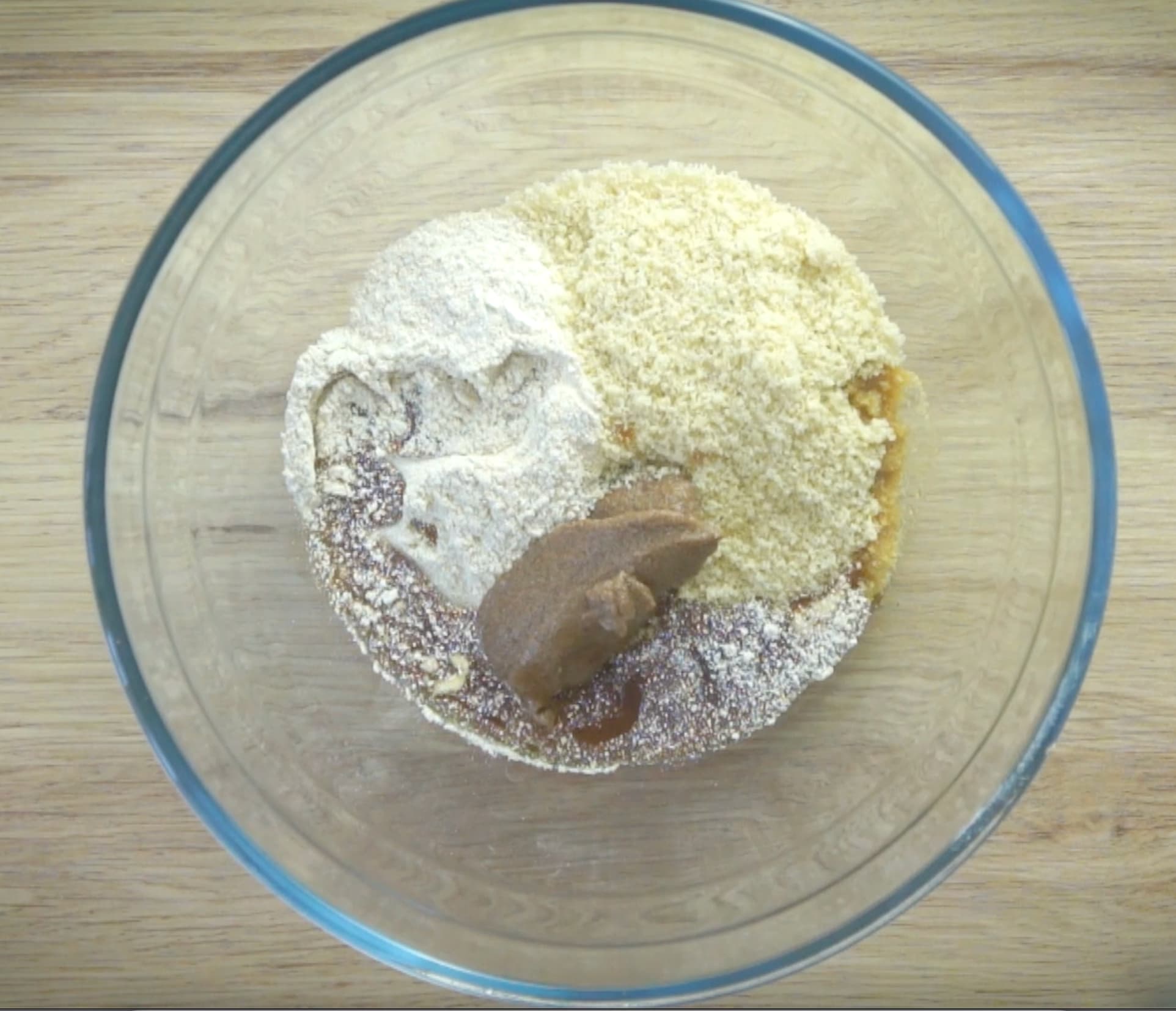 A glass bowl with flour, nut meal and ground flax seeds paste.