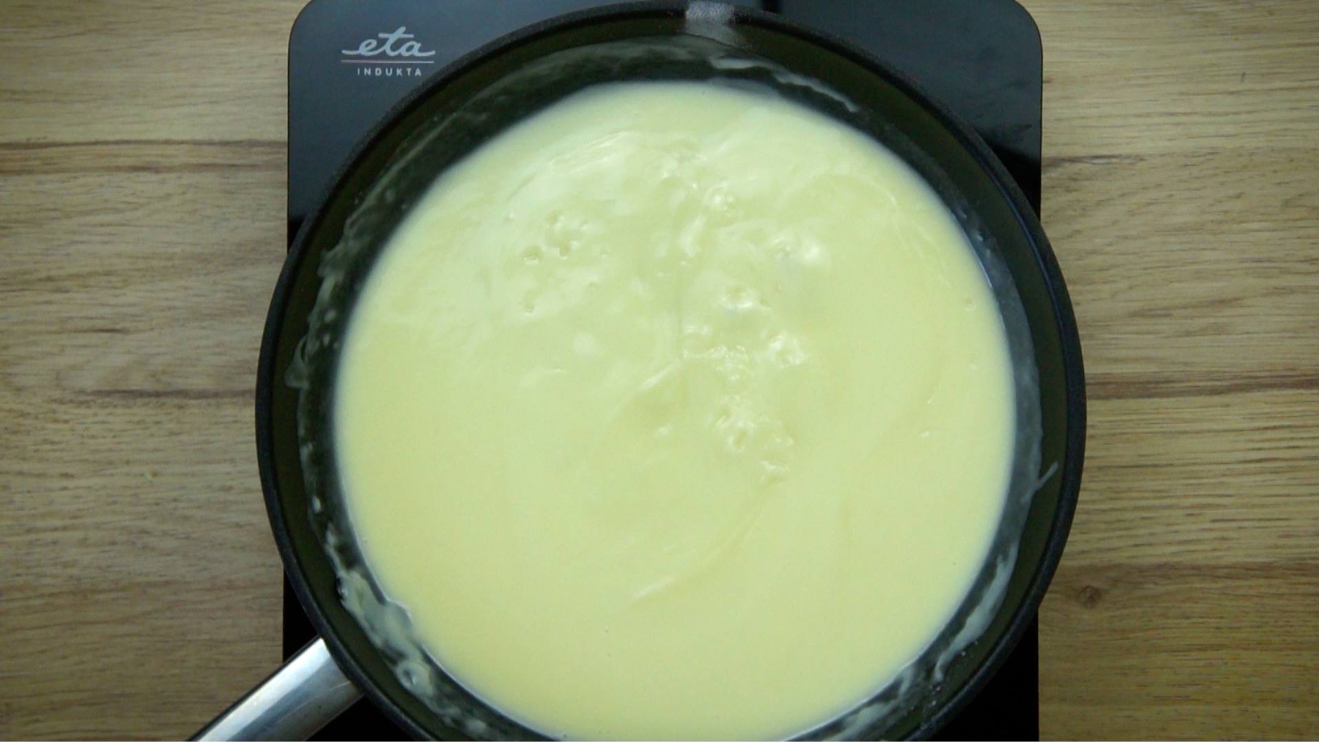 Frying pan with a light brown yellow sauce.