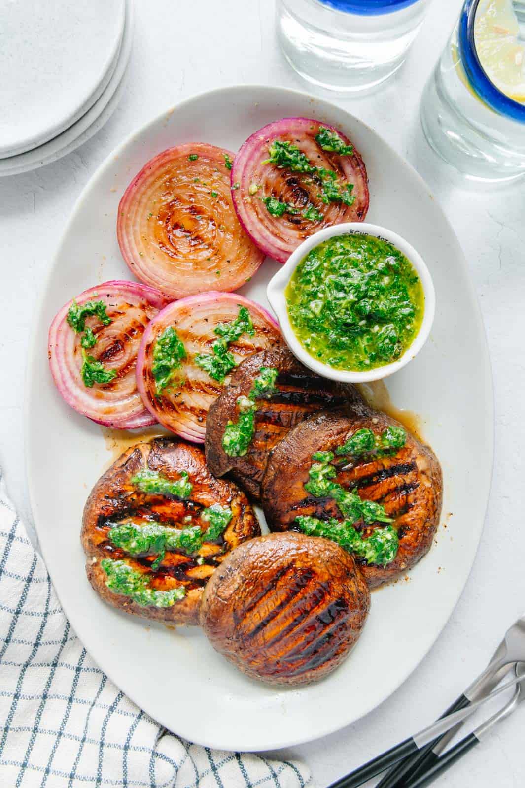 Grilled Portobello mushrooms and onions on a white plate.