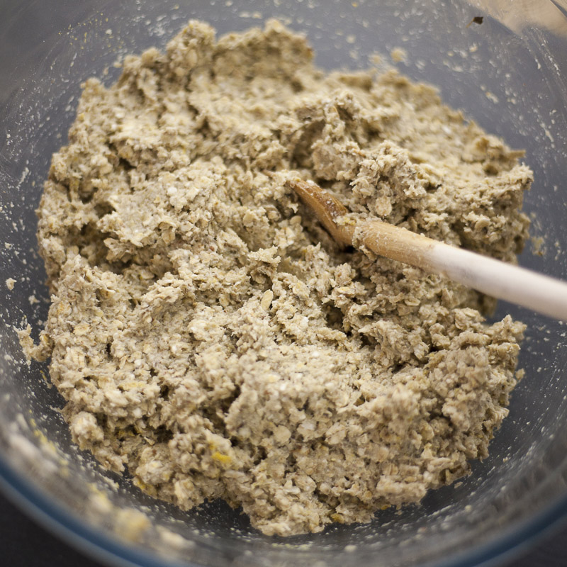 Glass bowl with the final mixture for the eggplant meatballs with a wooden spoon.
