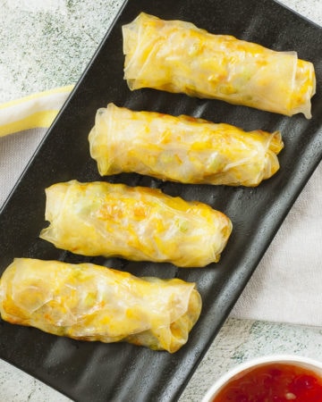 4 rice paper rolls on a black plate