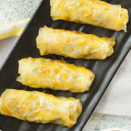 4 rice paper rolls on a black plate