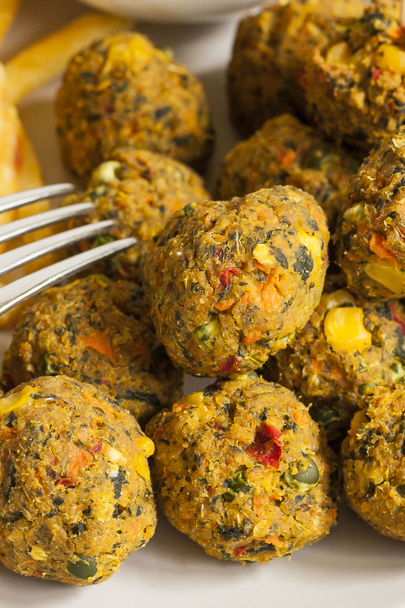 Close-up of small brown balls with red, yellow, green pieces in them.