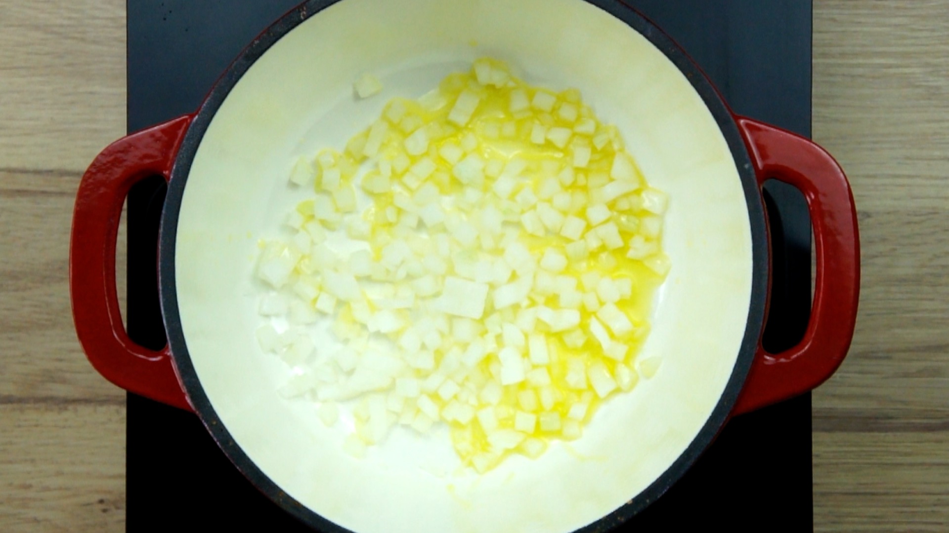 Red white Dutch oven with chopped onion.