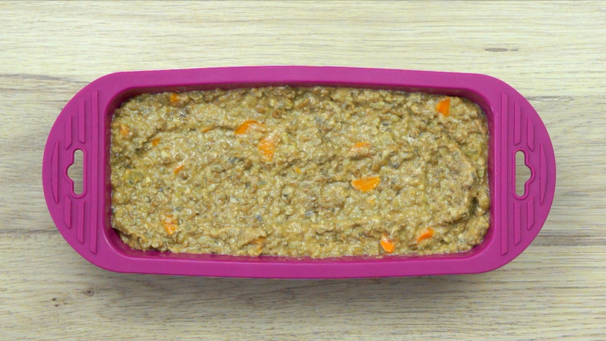 Purple loaf pan with a dark brown batter filled to the brim