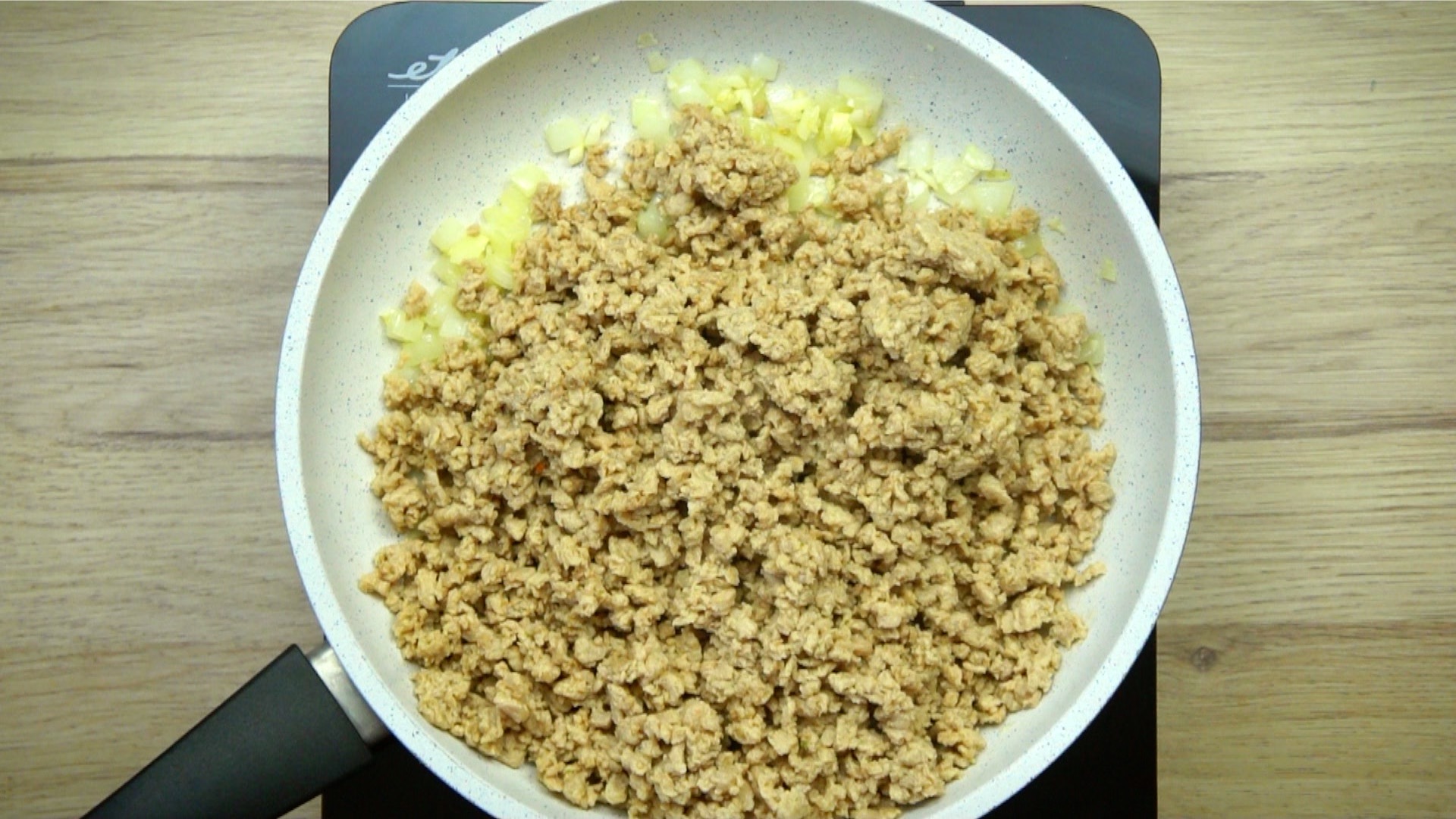White frying pan with light brown crumbles.