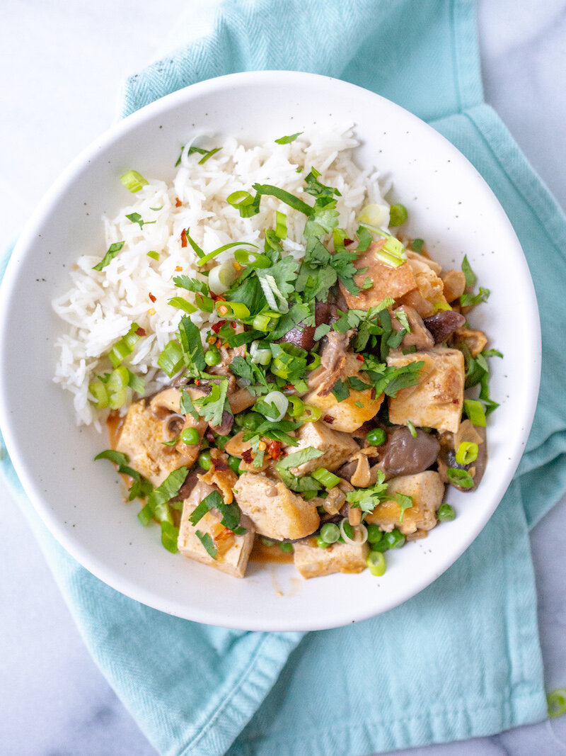 A bowl of rice and chicken in a white bowl.