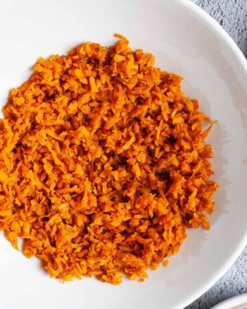 A large white plate in the middle orange riced sweet potato.