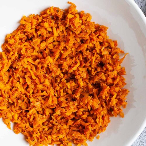 A large white plate in the middle orange riced sweet potato.