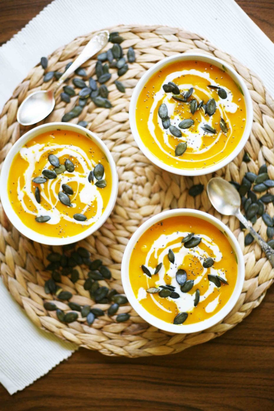 Simple Pumpkin Cream Soup from fresh Hokkaido pumpkin - 3 small bowl of pumpkin soup sprinkled with pumpkin seeds, chia seeds and dairy-free cream poured on top.