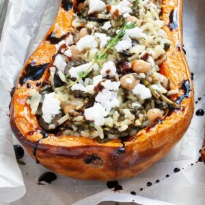 Spinach and rice served in a butternut squash boat topped with feta cheese and balsamic vinegar.