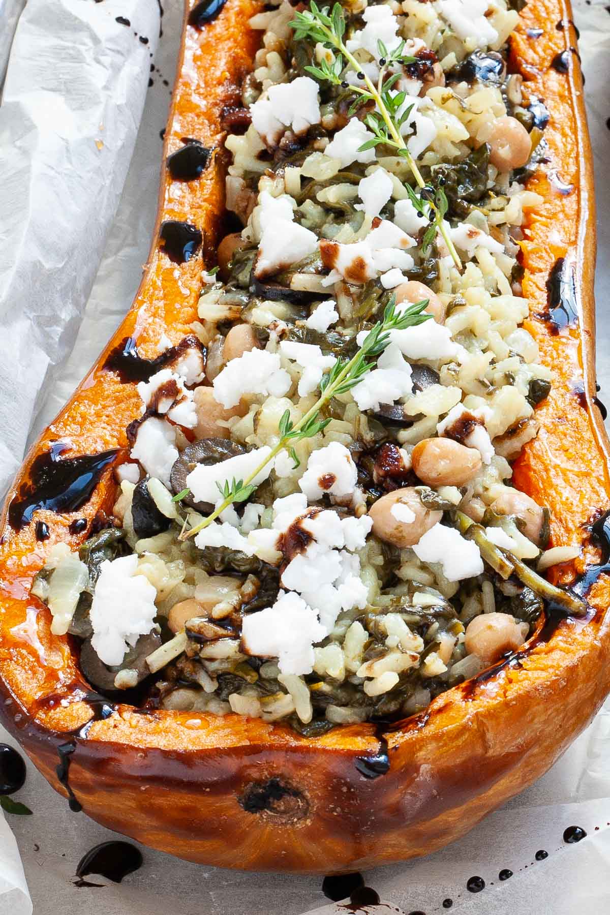 Spinach and rice served in a butternut squash boat topped with feta cheese and balsamic vinegar.