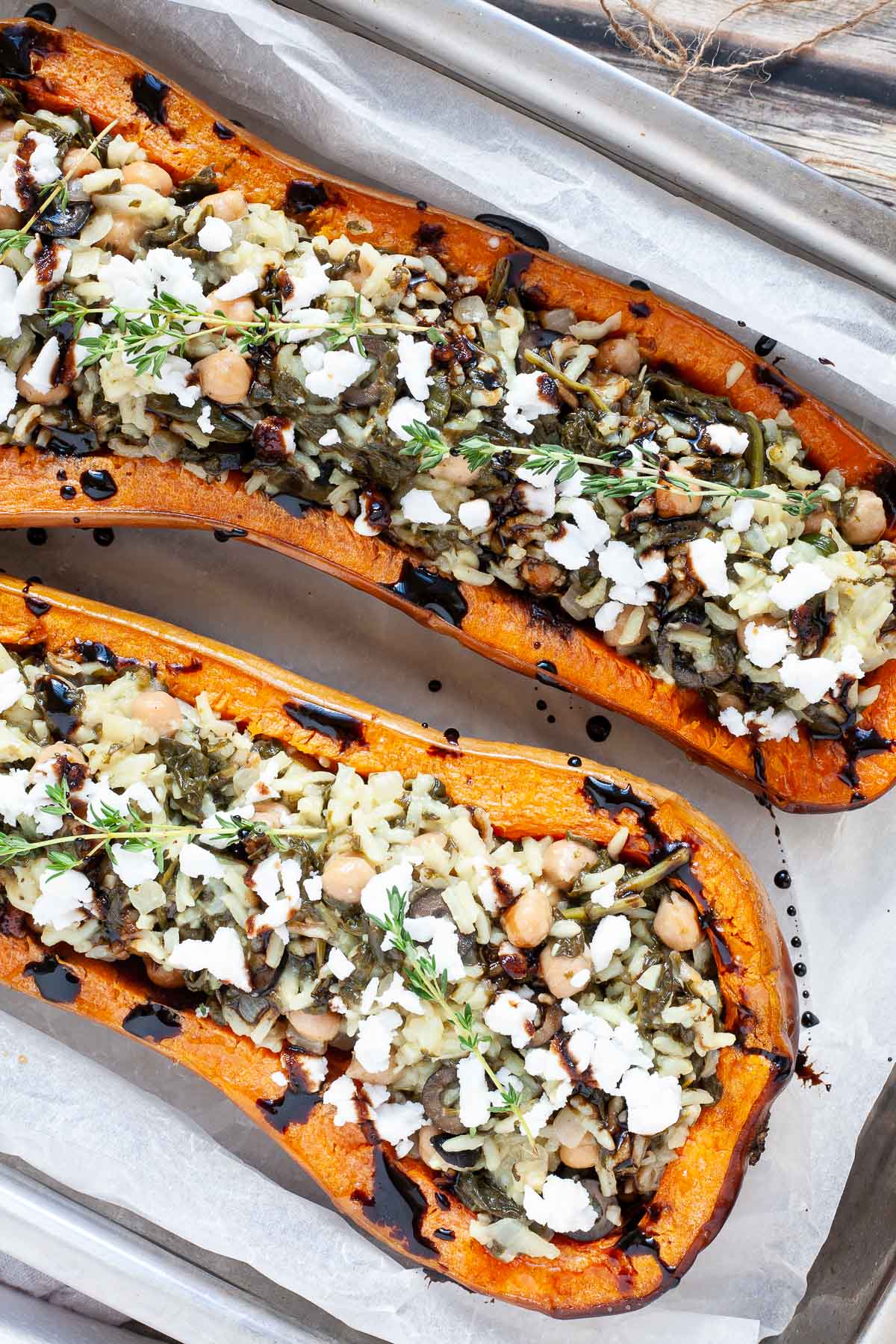 Spinach and rice served in two butternut squash boats topped with feta cheese and balsamic vinegar.