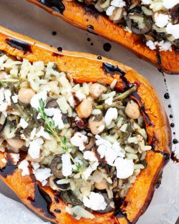 Spinach and rice served in two butternut squash boats topped with feta cheese and balsamic vinegar.