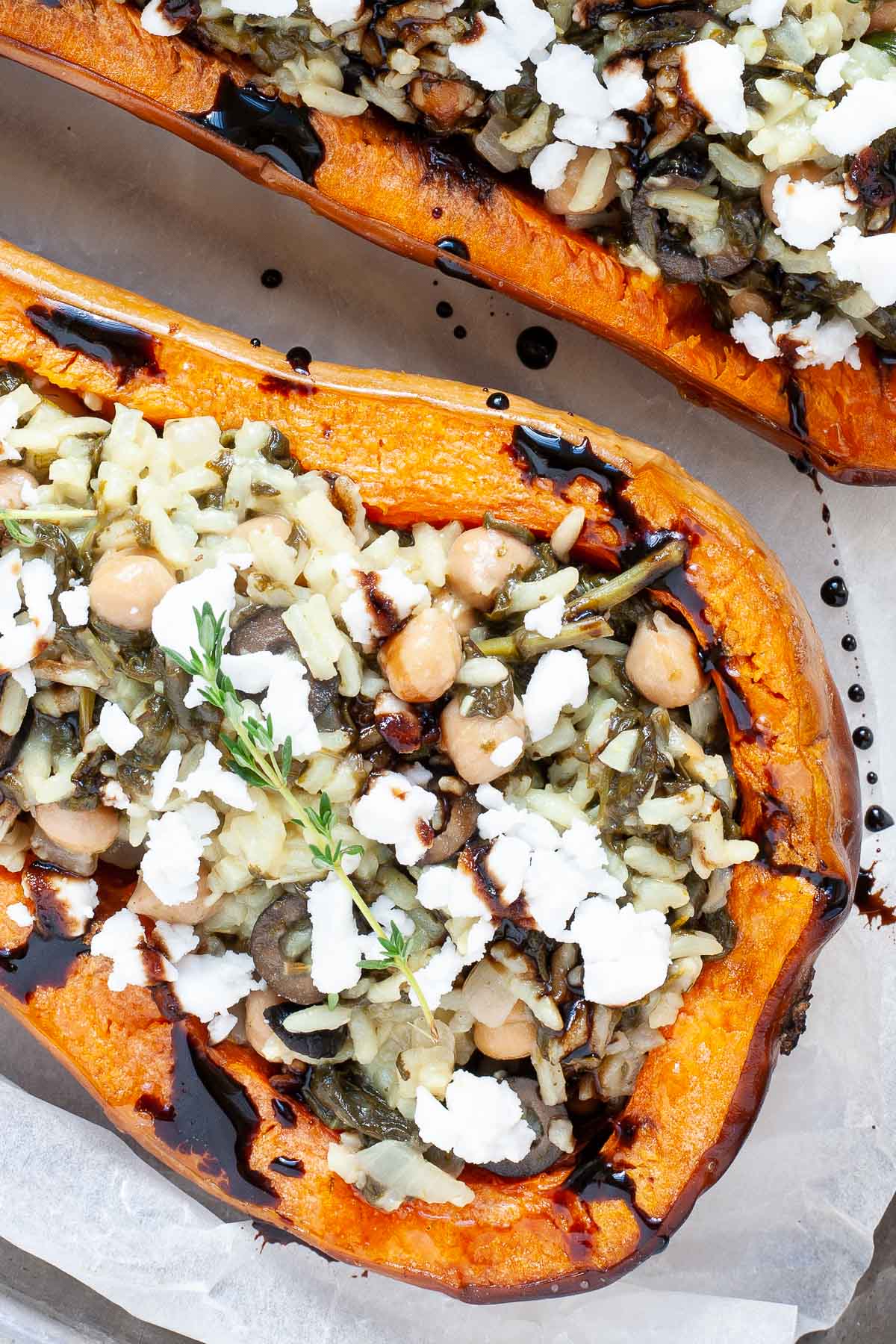 Spinach and rice served in two butternut squash boats topped with feta cheese and balsamic vinegar.