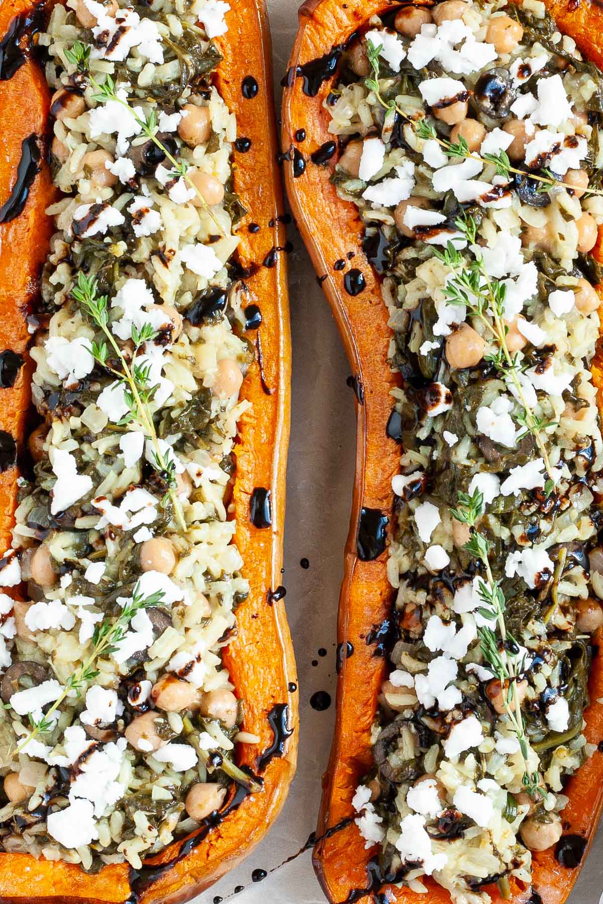 Spinach and rice served in two butternut squash boats topped with feta cheese and balsamic vinegar.