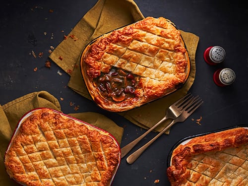 Pot pies from above in rectangle-shaped mini pots. You can see the mushroom filling in one of the corners.