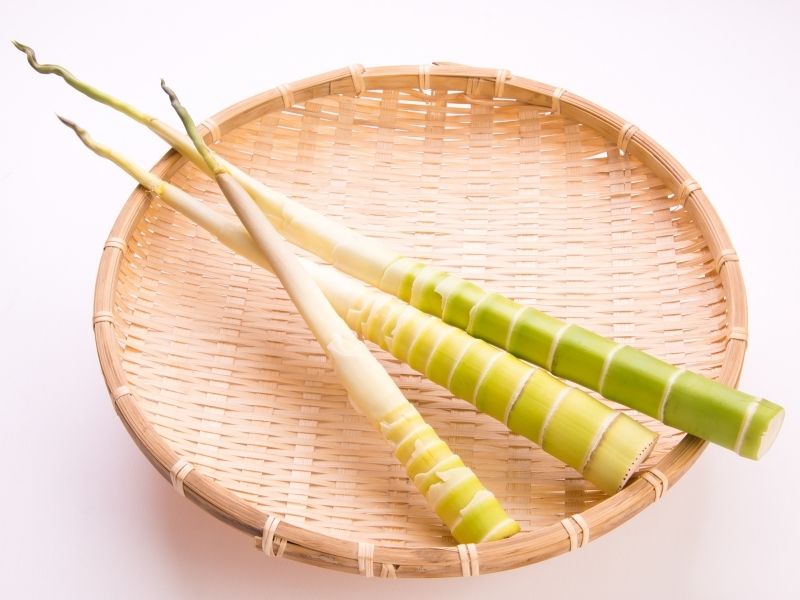 3 peeled bamboo shoots in a woven basket