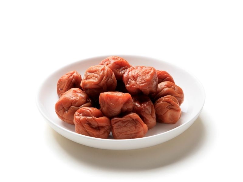 Red pickled plums on a white plate