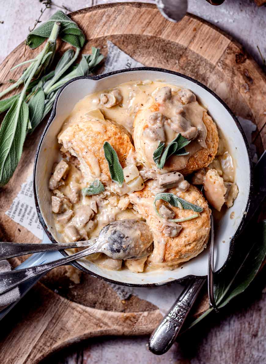 A round white casserole with mushroom gravy topped with round biscuits.