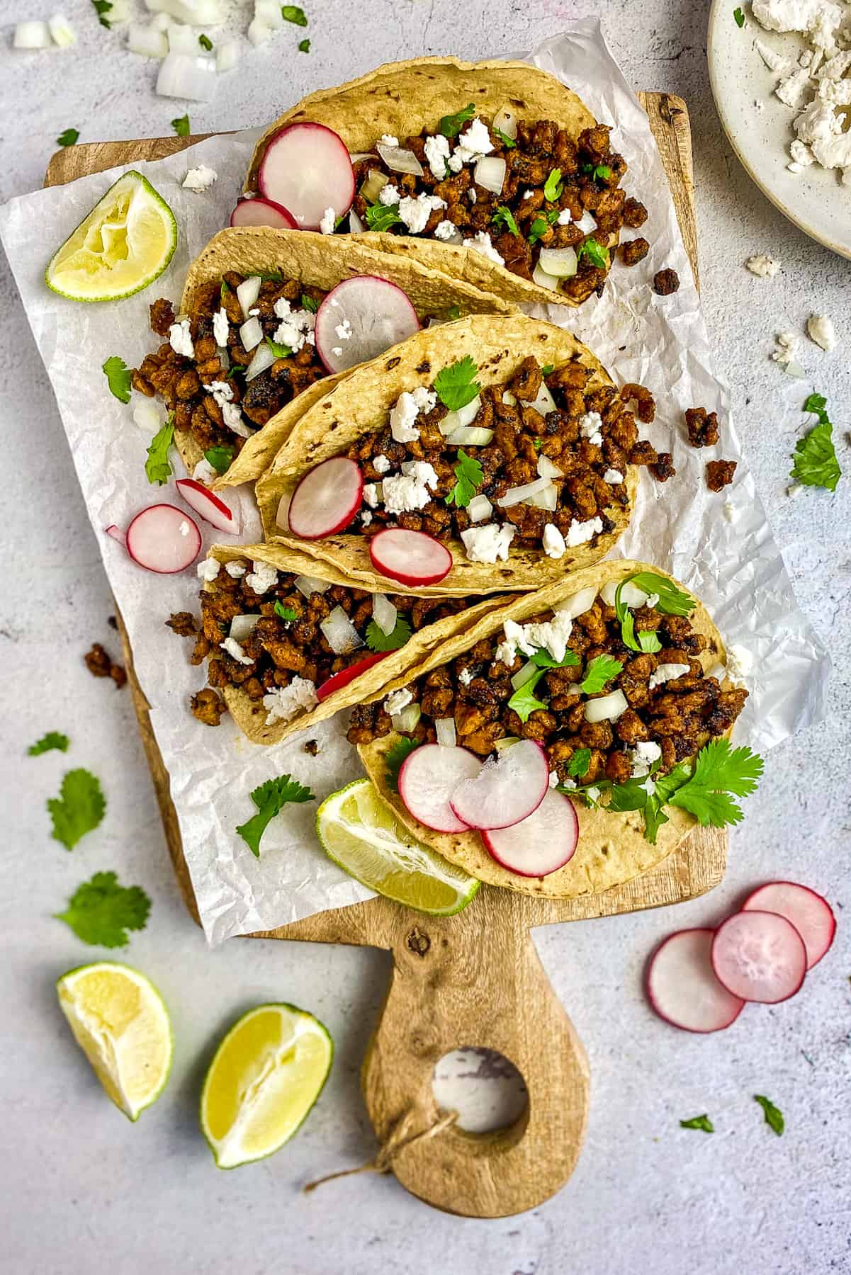 Vegan carne asada tacos on a cutting board.