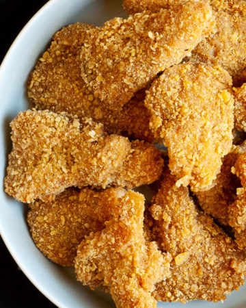 Brown breaded nuggets in a round plate.