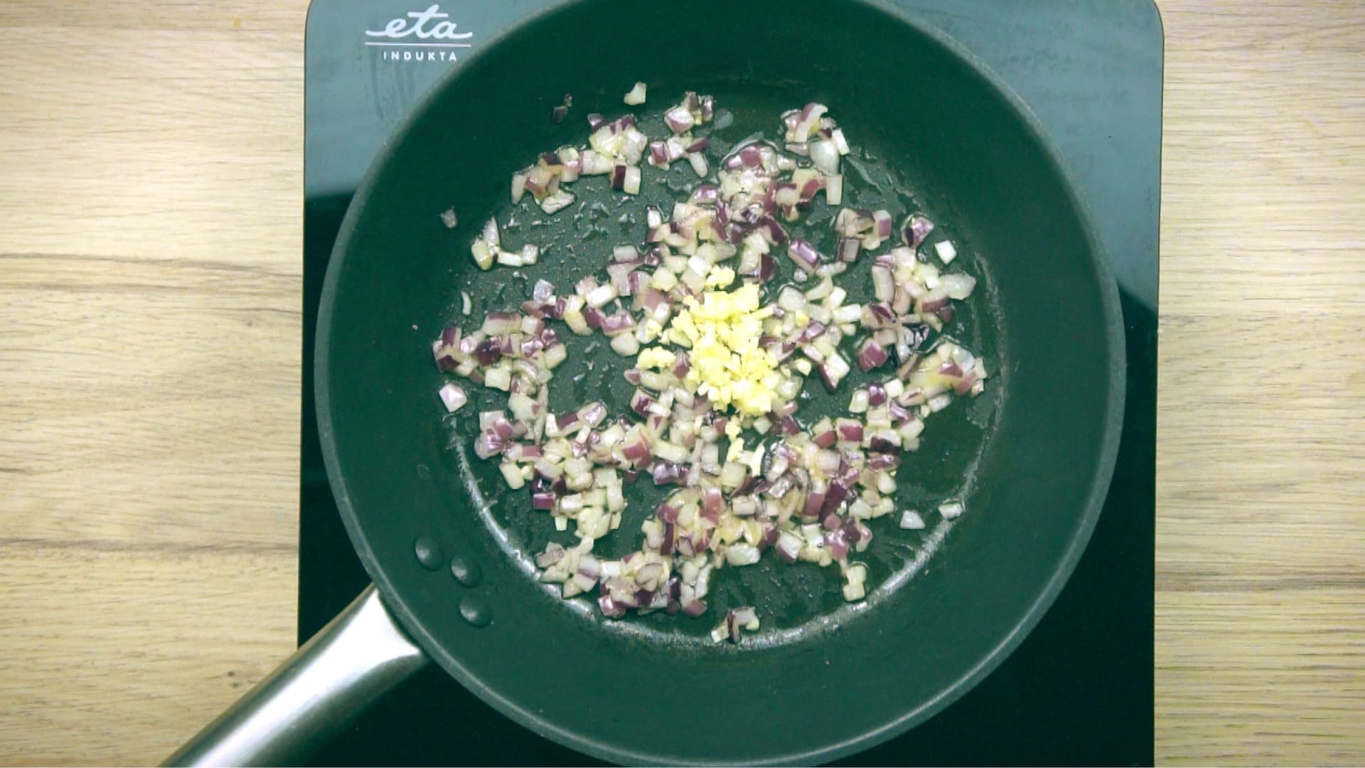 Frying pan with chopped onion and garlic.