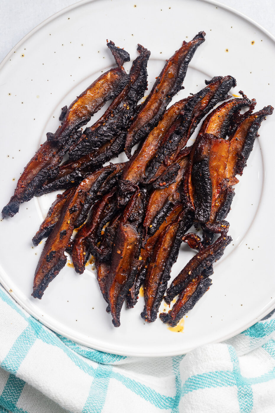 Crispy dark brown mushroom slices served on a white plate