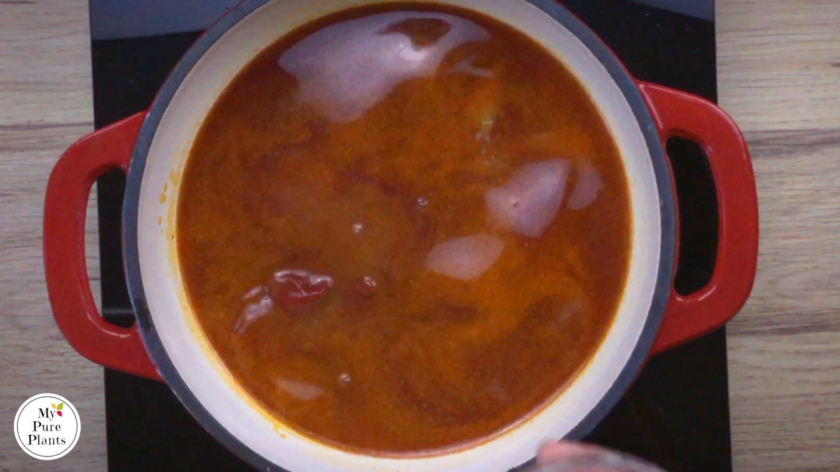 Red-white enameled Dutch oven with a thin red soup.