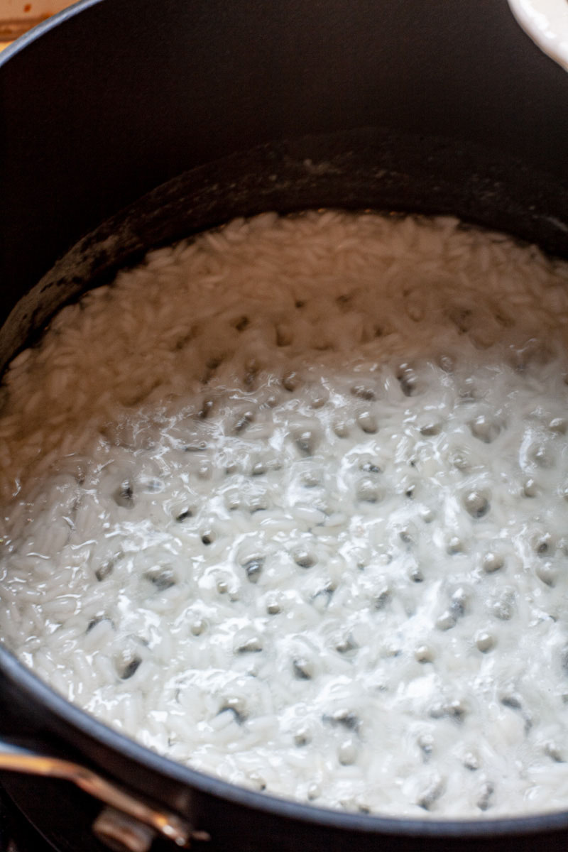 A black saucepan with rice bubbling during cooking