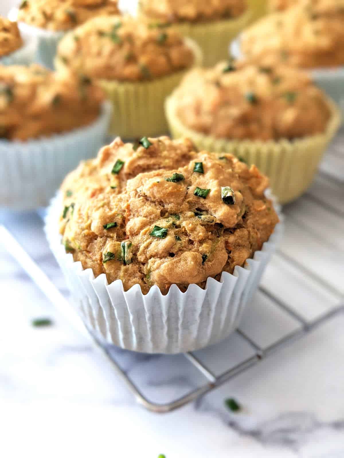 Muffins in white liners on a wire rack.