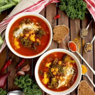 2 small white bowls with vibrant red stew and lots of veggies